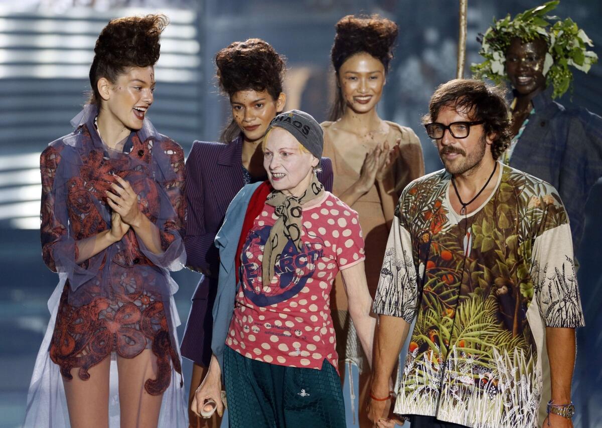 British fashion designer Vivienne Westwood, center, acknowledges the crowd alongside her husband, Andreas Kronthaler, during her 2014 spring/summer ready-to-wear collection fashion show at Paris Fashion Week.