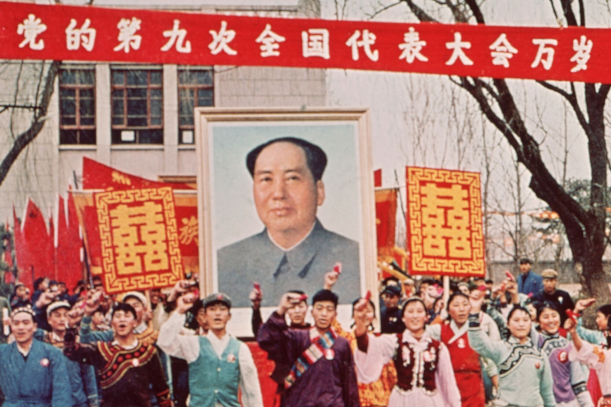 People march  carrying a large poster of Chairman Mao Zedong during the Cultural Revolution in China in 1968.