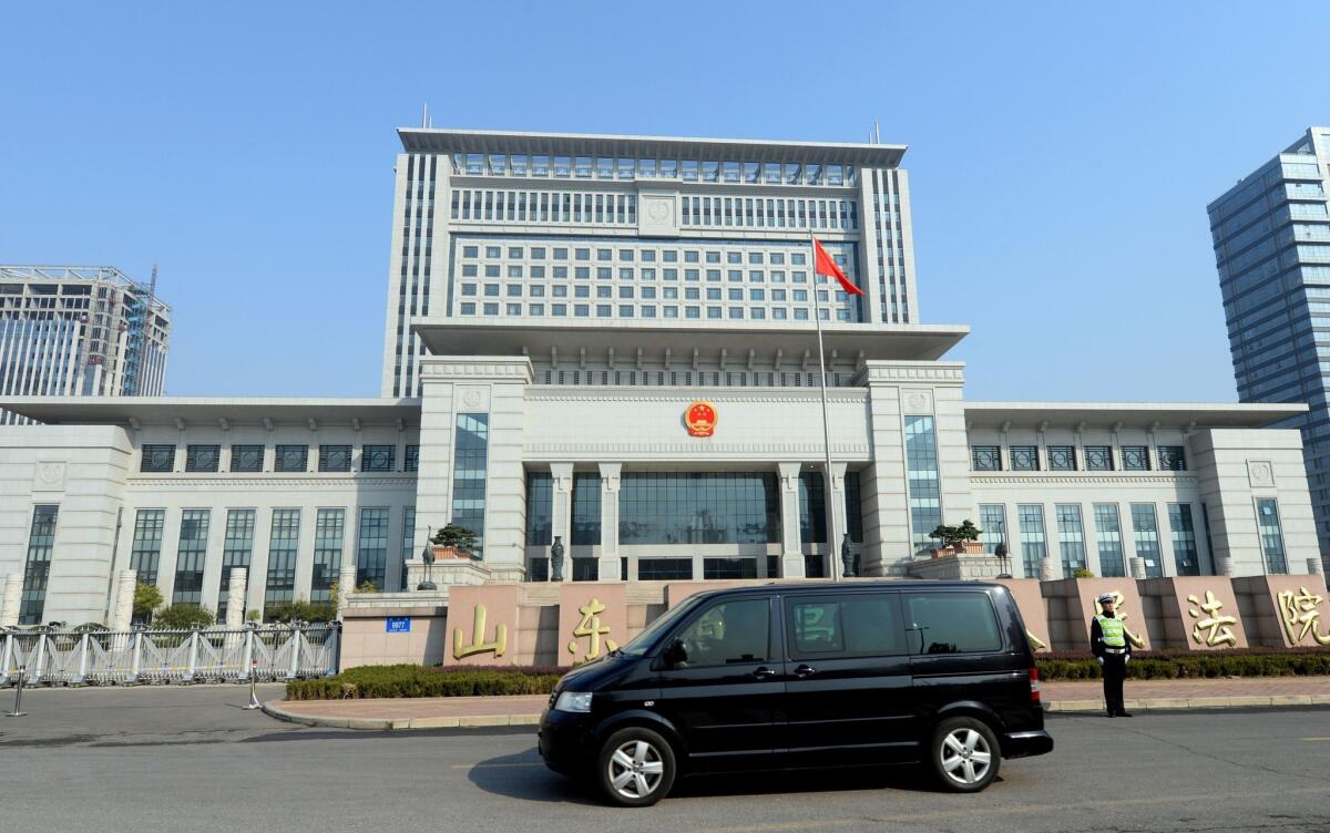 A vehicle believed to be ferrying once-powerful politician Bo Xilai arrives at the Shandong high court building in Jinan, in eastern China's Shandong province, on Friday.