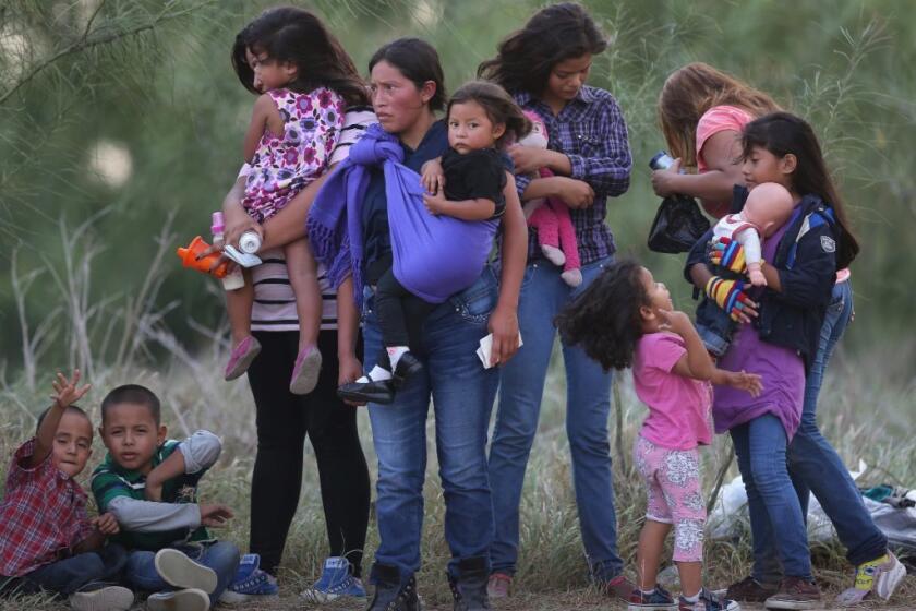 Central American immigrants await transportation to a U.S. Border Patrol processing center after crossing into the U.S. near Mission, Texas.