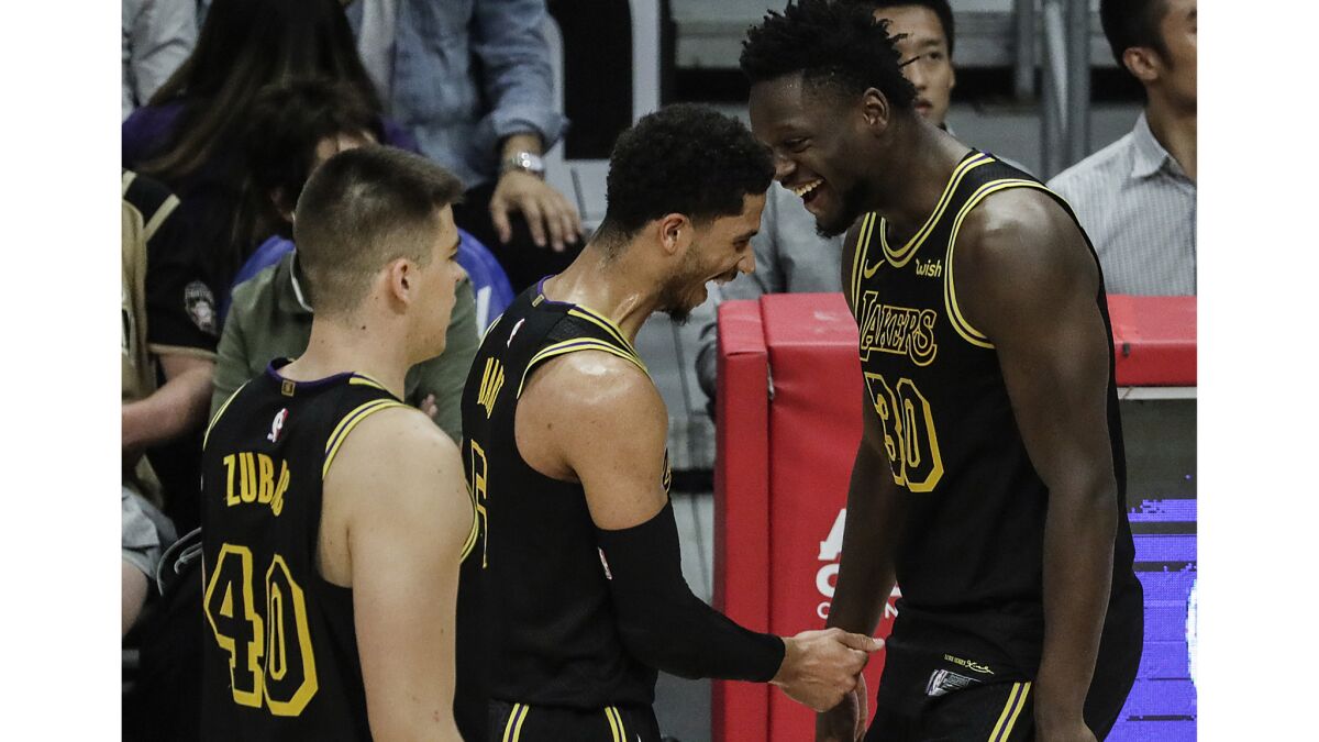 Lakers forward Julius Randle shares a laugh with teammate Josh Hart after the guard hit a three-pointer, helping lead the team past the Clippers in the second half.