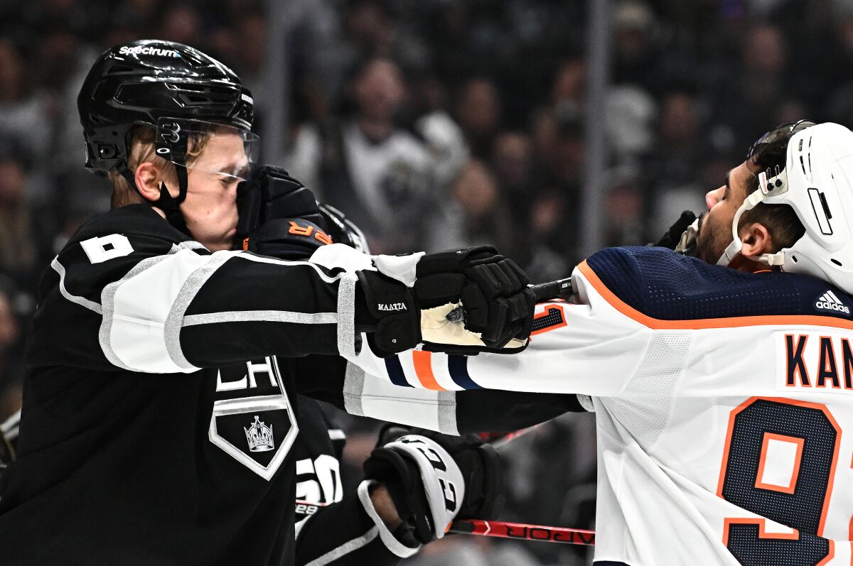 Kings' Olli Maatta and Edmonton Oilers' Evander Kane push each other.