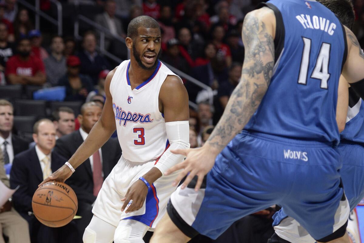 Clippers point guard Chris Paul looks for an opening past Timberwolves center Nikola Pekovic.