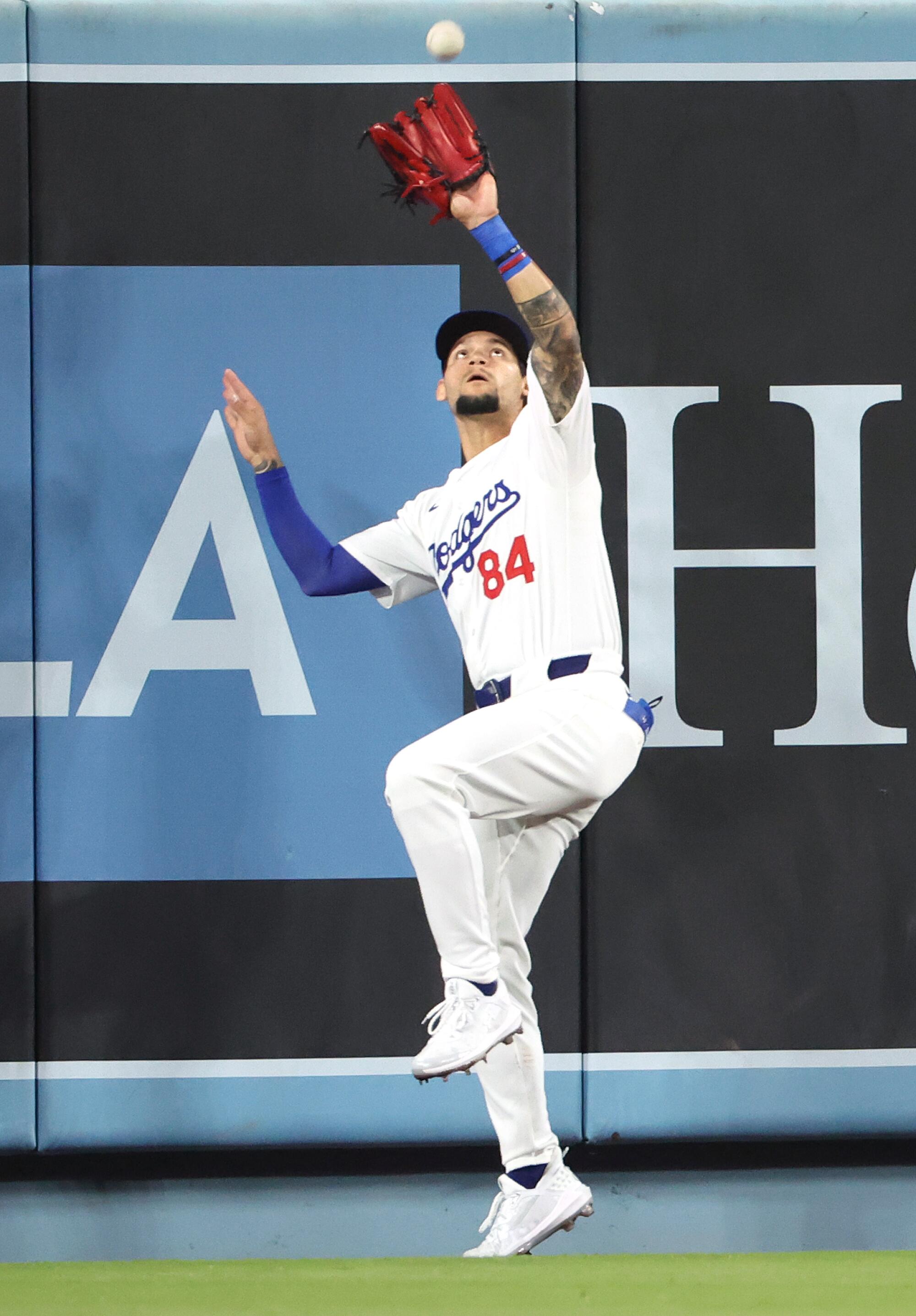 Dodgers center fielder Andy Pages makes a catch at the wall during a game against the Nationals.