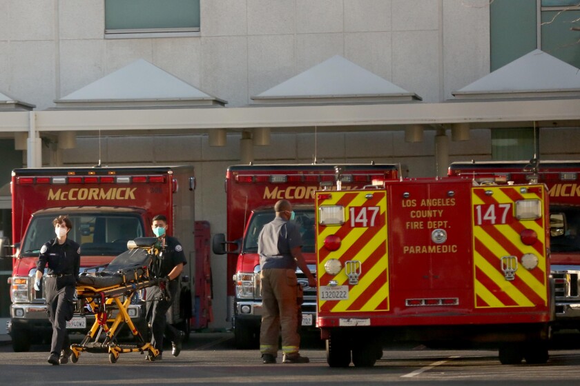 LYNWOOD, CA - JANUARY 21, 2021 - Paramedics bring their stretcher back to their vehicle after carting a patient into the Emergency at St. Francis Medical Center in Lynwood on January 21, 2021. The hospital has been treating 150 patients a day at the height of the recent surge. The hospital has treated more than 2,900 COVID-19 positive patients since last March, according to Linda Woo in media relations for the hospital. (Genaro Molina / Los Angeles Times)