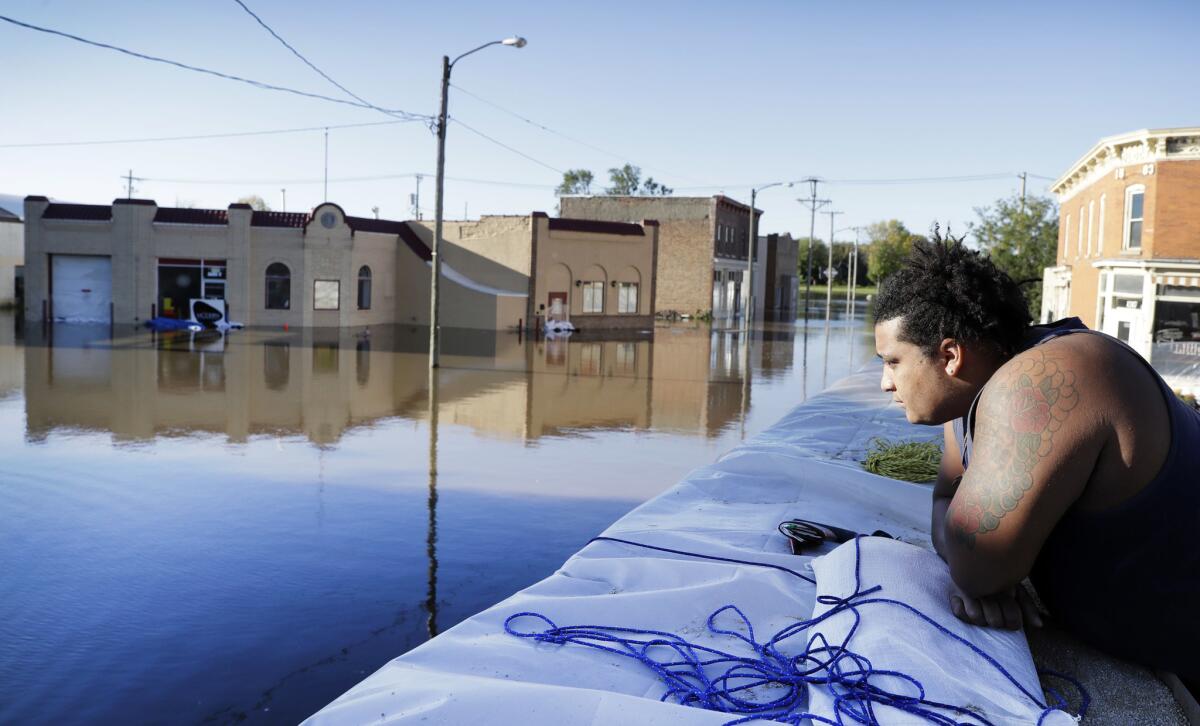 Cory Harrison stands on a flood wall as he looks over businesses flooded by the Cedar River on Sept. 27 in Cedar Rapids, Iowa.