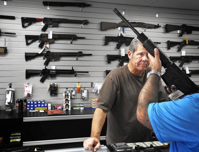 Frank Cobet shows a customer an AR-15 rifle at the Get Loaded gun store in Grand Terrace in San Bernardino County in 2015.