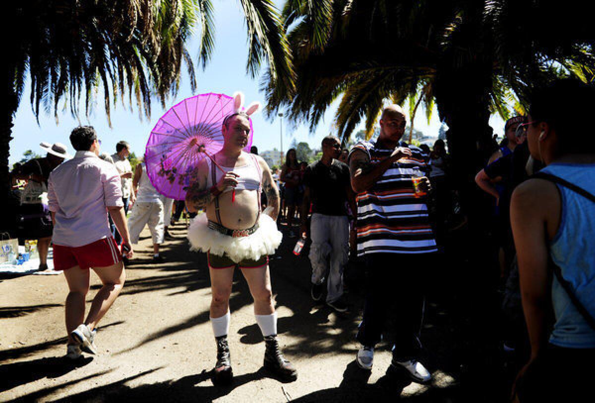 Joel Eden, with umbrella, stands among the crowd at the annual Dyke March held Saturday in San Francisco's Dolores Park.
