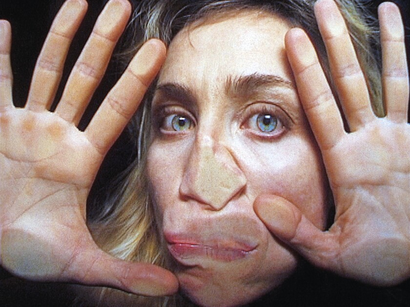 An image from Pipilotti Rist's 2000 video "Open My Glade": A woman's face and hands face the camera, pressed up to glass