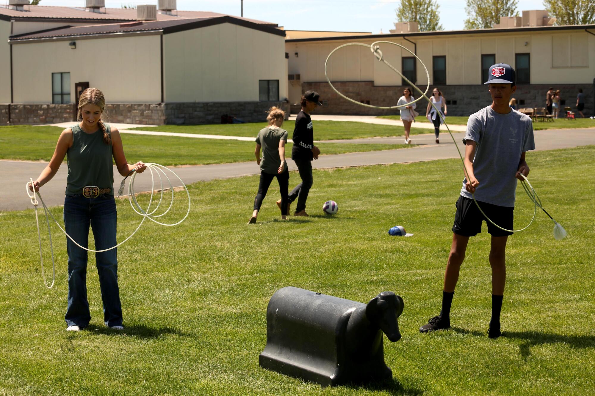 Mackenzie Hughes, left, and Axel Salazar, practice calf roping at Modoc High School during a student activity day.