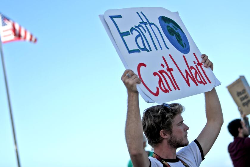 Forrest Houldin of Mission Viejo hold a protest sign during the Climate Strike climate change protest, at Main Beach Park in Laguna Beach on Friday, Sept. 20, 2019. People throughout the world came out today to protest against climate change.