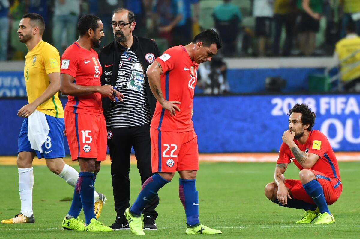Chile's Jean Beausejour (2-L), Esteban Paredes (C) and Jorge Valdivia (R) show their dejection after being defeated by Brazil in a qualifier match and missing the 2018 World Cup football tournament, in Sao Paulo, Brazil, on October 10, 2017.