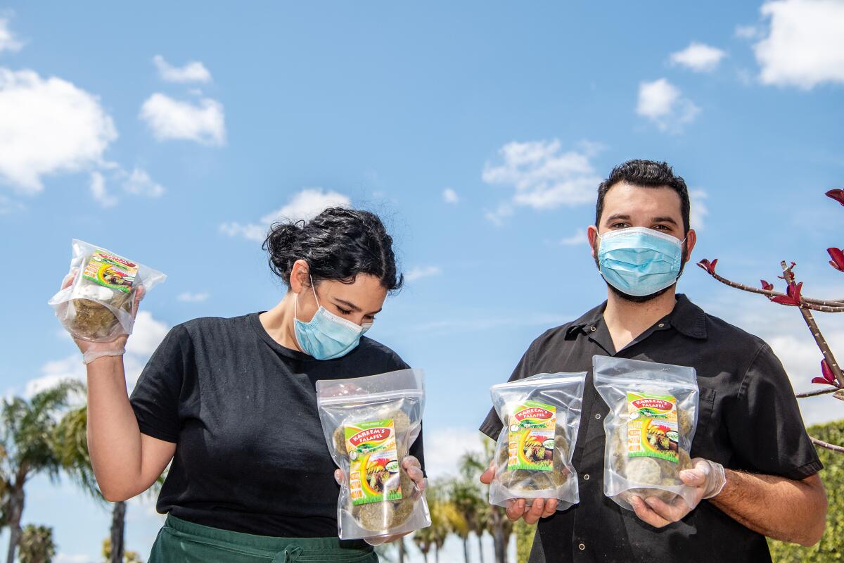 Siblings Nora and Kareem Hawari with their falafel packages.