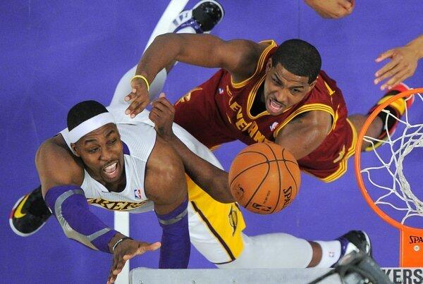 Lakers center Dwight Howard, left, puts up a shot as Cleveland Cavaliers forward Tristan Thompson defends.