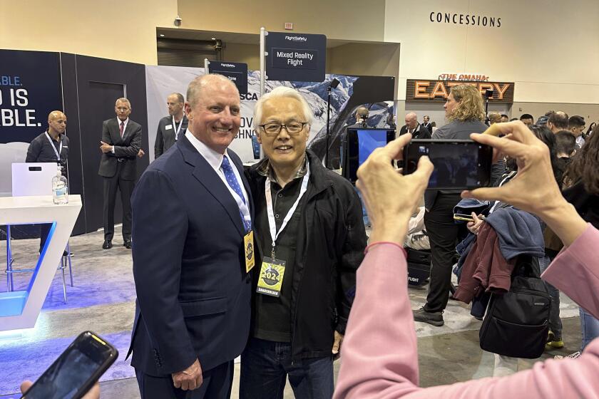 Berkshire Hathaway Vice Chairman Greg Abel poses for pictures with shareholders while touring the booths Berkshires companies set up, Friday, May 3, 2024, in Omaha, Neb. Abel will succeed Warren Buffett as CEO one day. (AP Photo/Josh Funk)