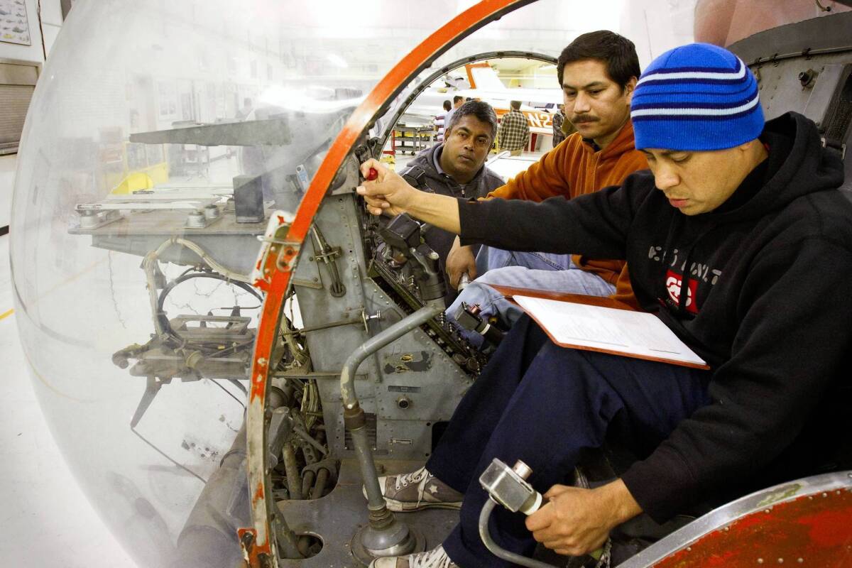 Students Ronald Quijada, Mayko Alonso and Chandana Koralalage, front to back, go through the starting and shutting down procedures on a TH-13T helicopter.