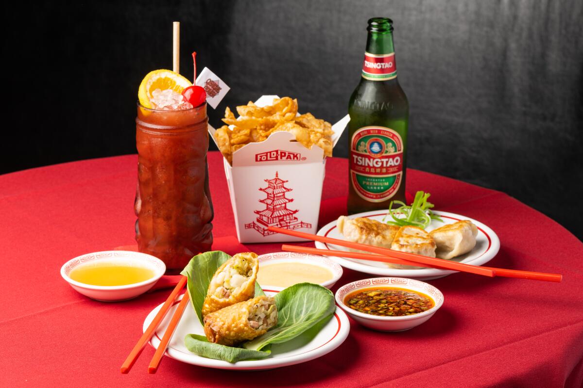 A selection of cocktails and bites on a round table's red tablecloth