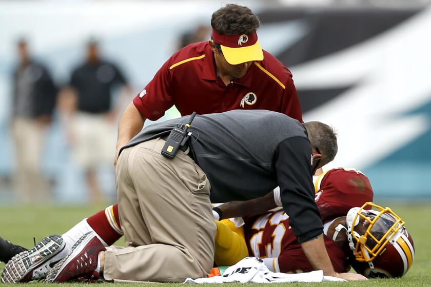 Redskins cornerback DeAngelo Hall is tended to by trainers after injuring his Achilles tendon in the second half of a game against the Eagles on Sunday in Philadelphia.