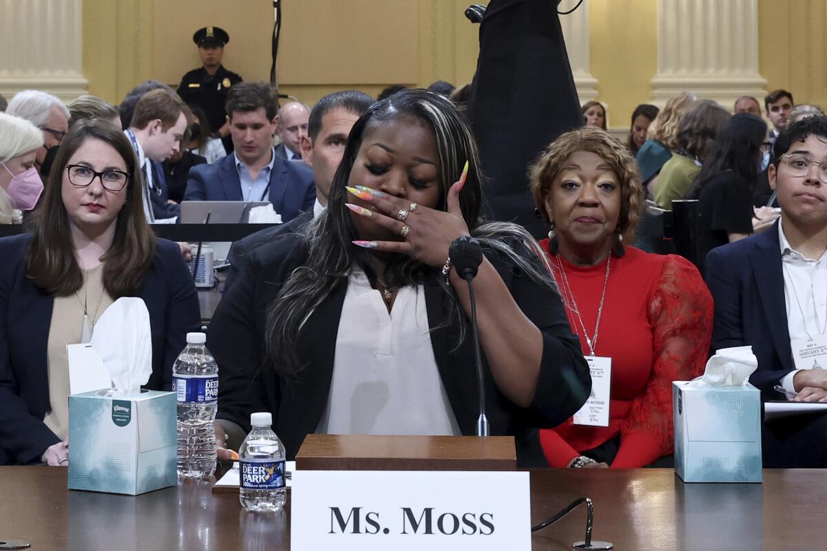 Emotional woman testifying with name card reading "Ms. Moss" 
