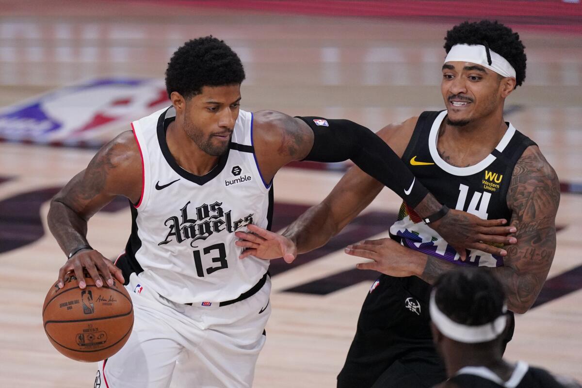 The Clippers' Paul George drives past the Denver Nuggets' Gary Harris.