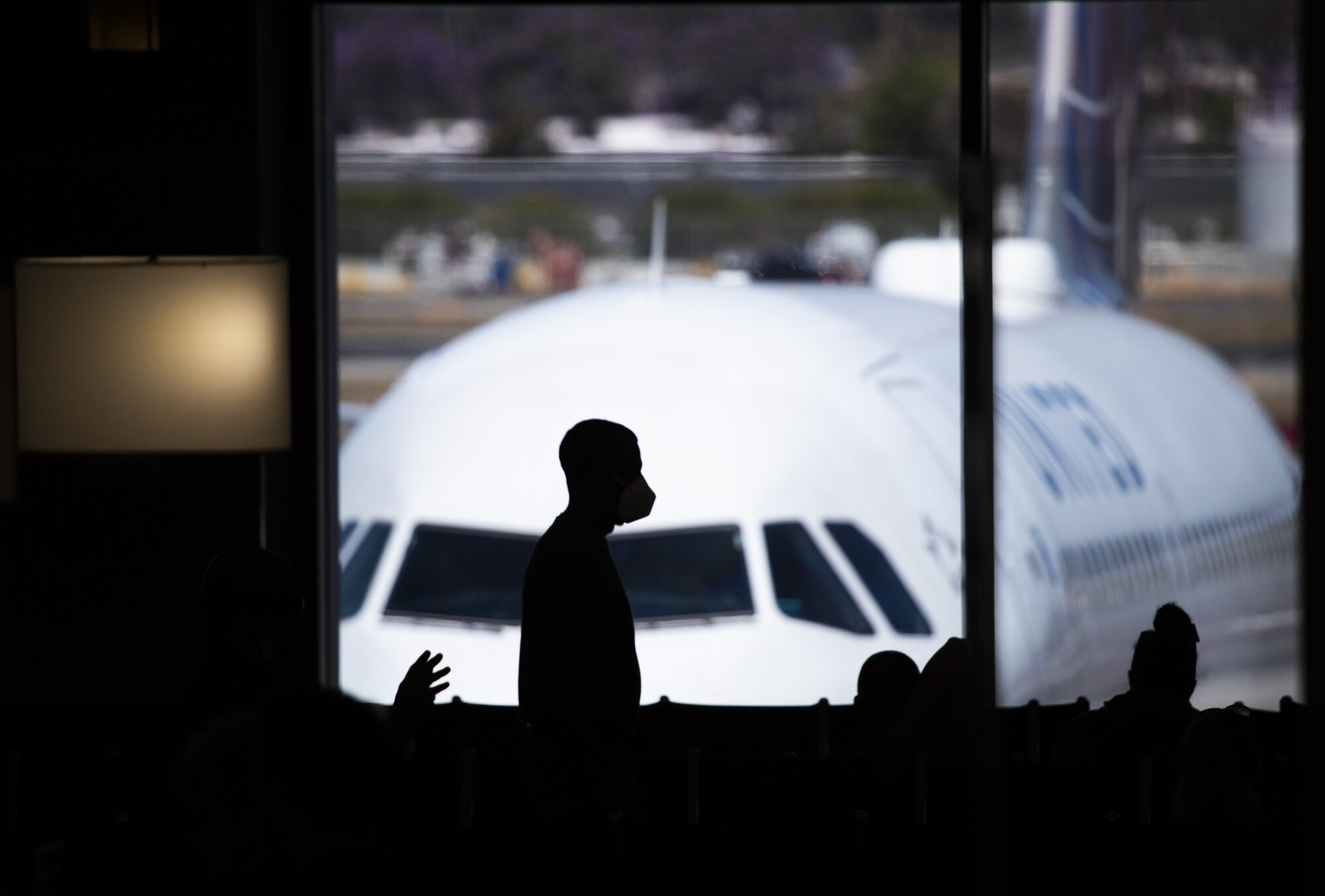A plane prepares to be loaded as passengers make their way to their gates at John Wayne Airport in Orange County