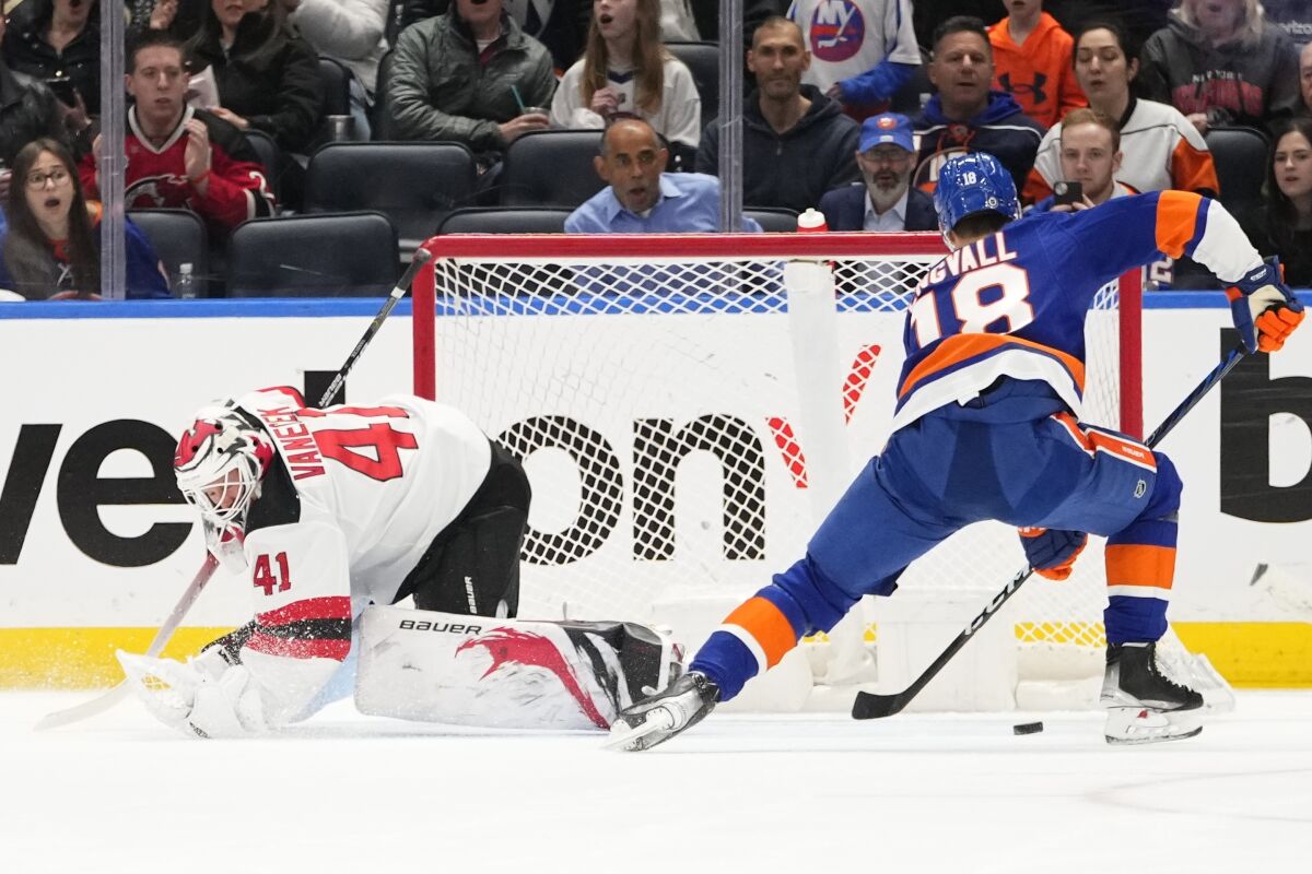 New York Islanders' Pierre Engvall (18) drives past New Jersey Devils goaltender Vitek Vanecek (41) to score a goal during the first period of an NHL hockey game Monday, March 27, 2023, in Elmont, N.Y. (AP Photo/Frank Franklin II)