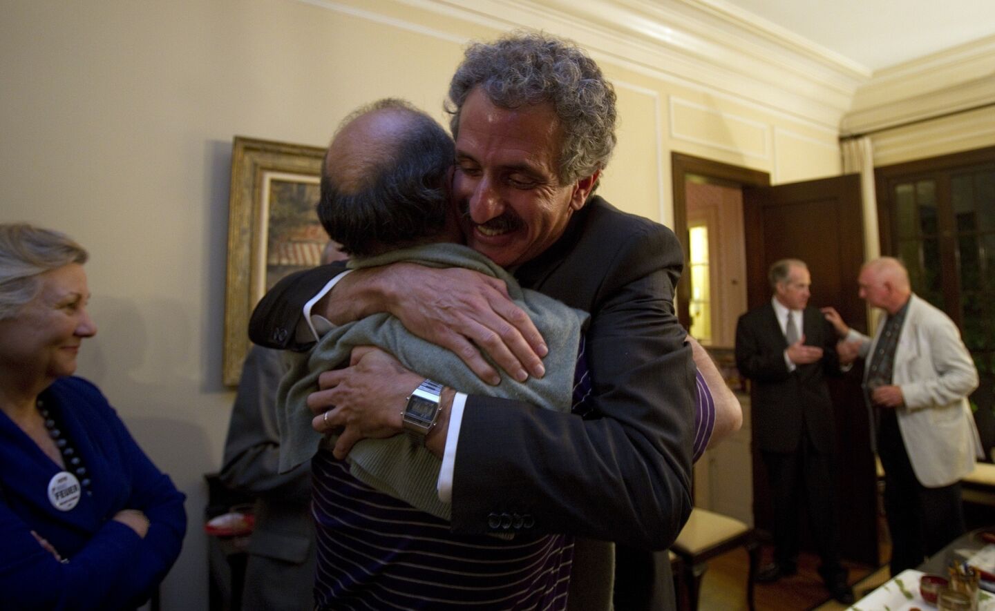 Mike Feuer, right, a candidate for city attorney, gets a hug from his friend Leon Alkalai on election night.