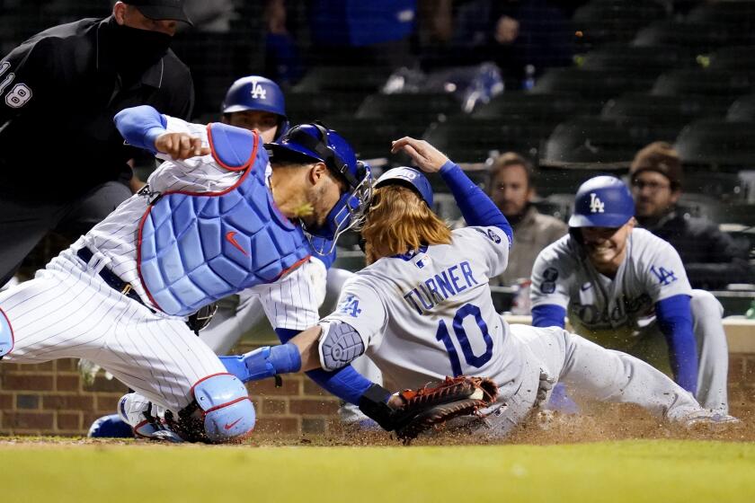 Chicago Cubs catcher Willson Contreras, left, tags out Los Angeles Dodgers' Justin Turner at home during the 10th inning of a baseball game in Chicago, Wednesday, May 5, 2021. (AP Photo/Nam Y. Huh)