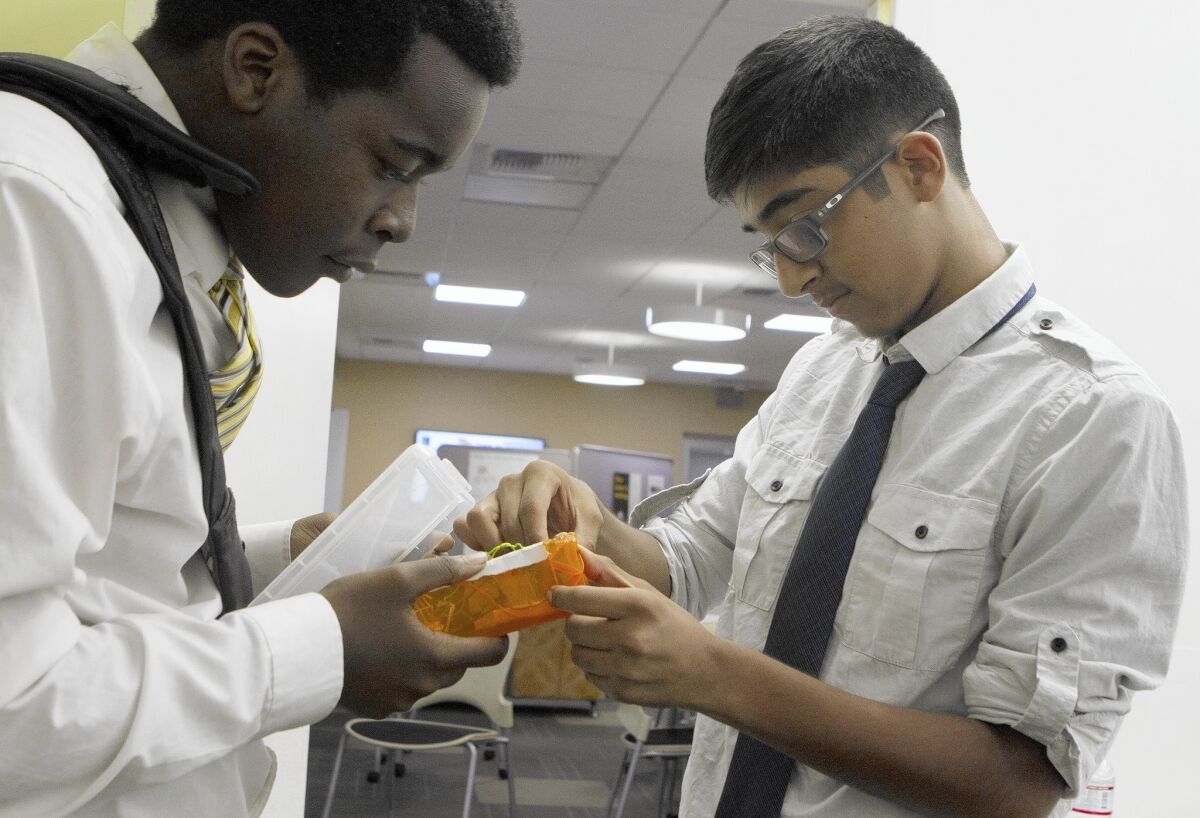 Urban TxT students Jacques Tolefree, 18, left, and Cesar Alvarenga, 15, make sure their device works before rehearsing their pitch for South L.A. Demo Day.