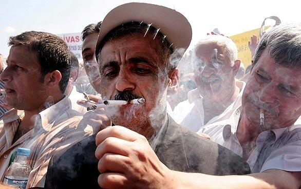 Turkish coffee shop owners smoke multiple cigarettes during a protest against the government's indoor smoking ban in Ankara. Turkey on July 19 introduced a nationwide ban on indoor smoking, including bars, restaurants and coffee shops.