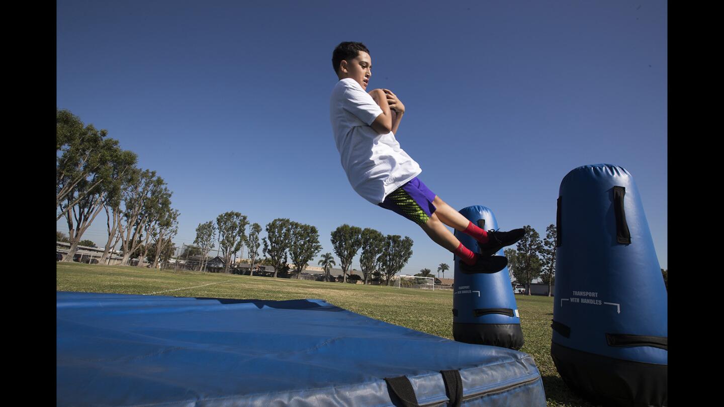 Jordan Martin, 11, dives onto a pad during the Los Angeles Chargers Junior Training Camp at Killybrooke Elementary School on Friday, Oct. 27.