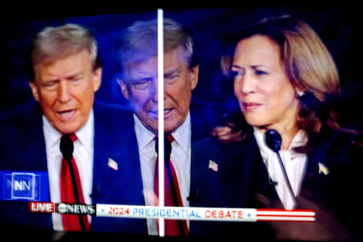 A double image of Donald Trump and one of Kamala Harris shown onscreen in the spin room during the second presidential debate