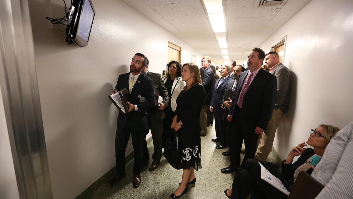Lobbyists and advocates watch the action in the state Assembly on a television outside the Assembly Chambers. A record amount was spent on lobbying in 2018.