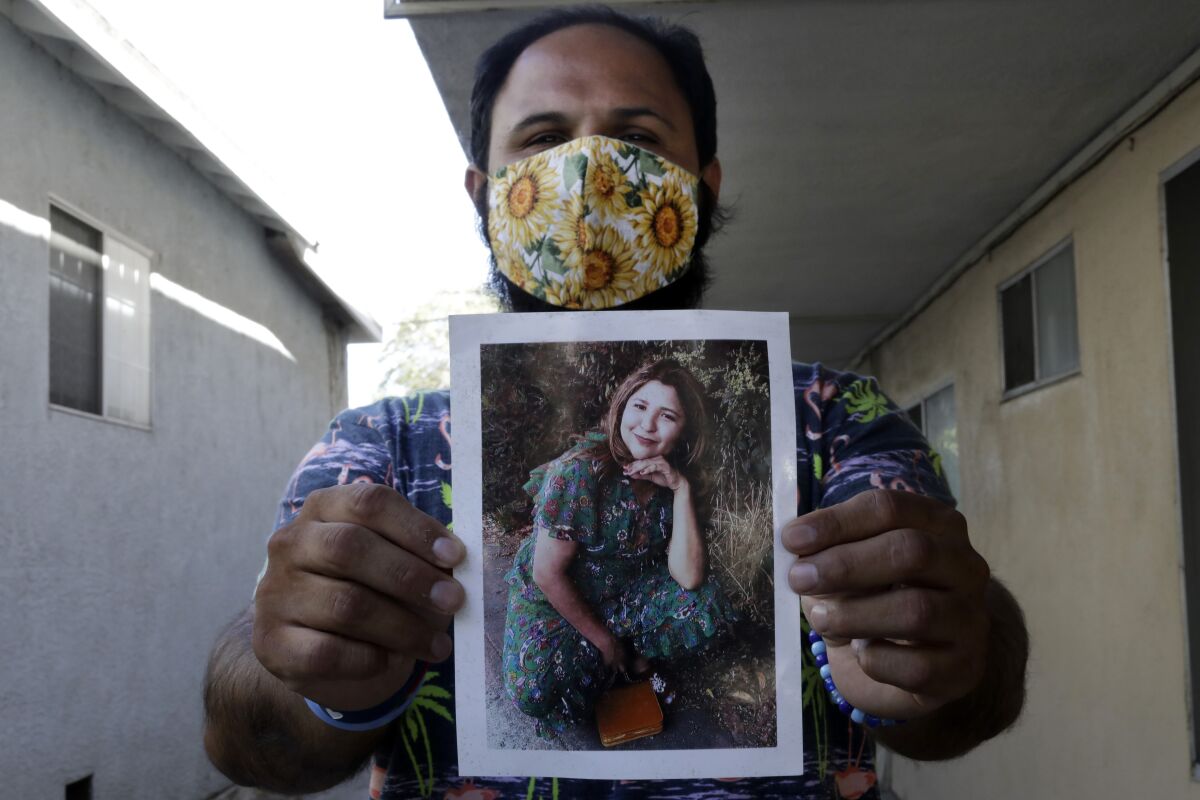 Albert Corado sostiene una foto de su hermana Melyda, quien fue asesinada a tiros por un oficial del LAPD