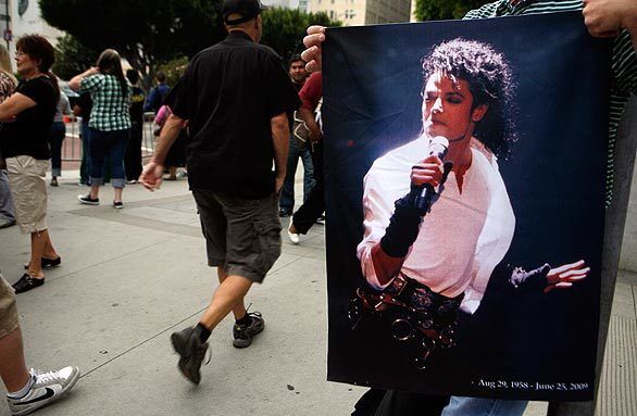 A street vendor holds a Michael Jackson picture for sale at 11th and Flower streets near Staples Center in Los Angeles.
