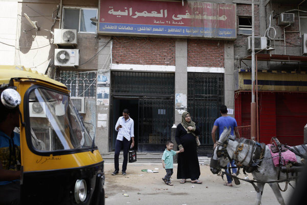 Egyptians walk in front of Al-Omraniyah hospital, run by the Muslim Brotherhood's Islamic Medical Assn., in Cairo on Saturday. An Egyptian court this week ordered a ban of the Brotherhood and confiscation of its assets, followed Wednesday by an order closing a newspaper linked to the group.