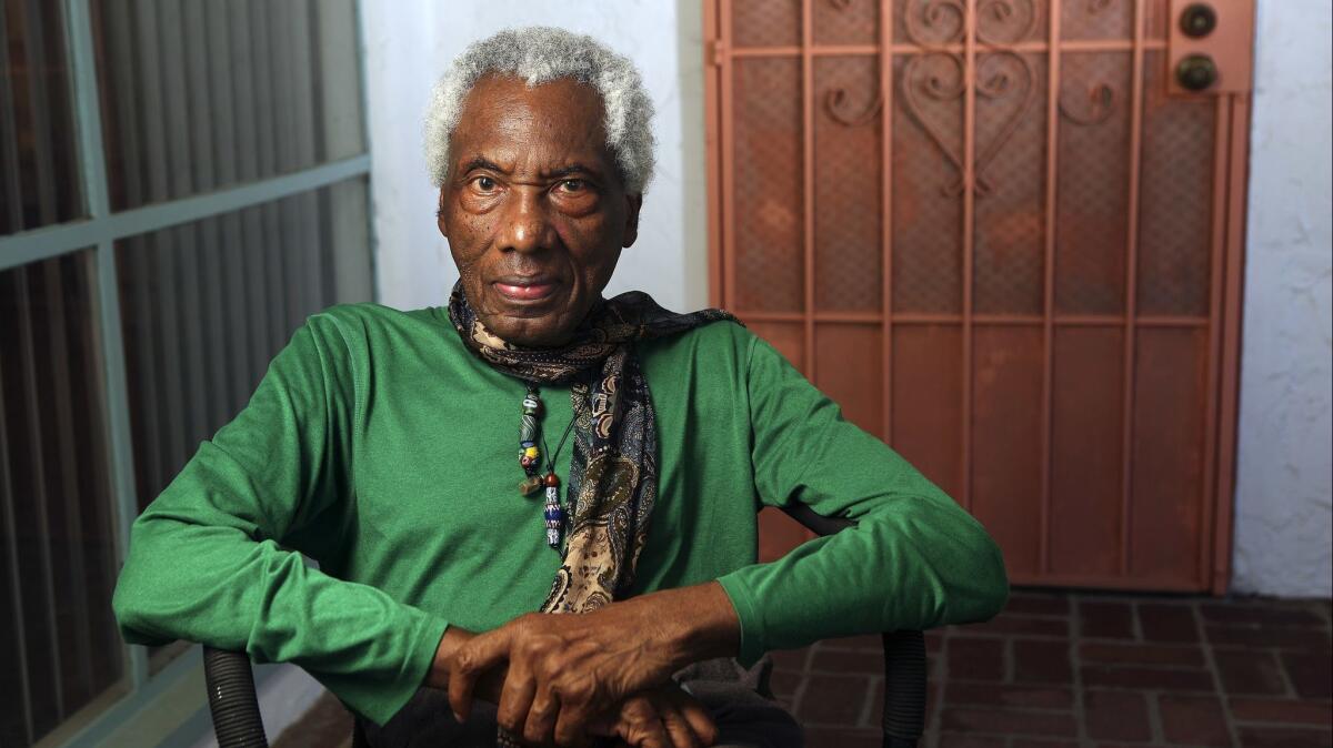 Artist John Outterbridge sits outside his Altadena home in 2015