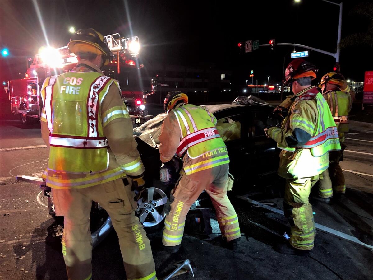 Firefighters extricate a man from his vehicle near Harbor Boulevard and South Coast Drive.