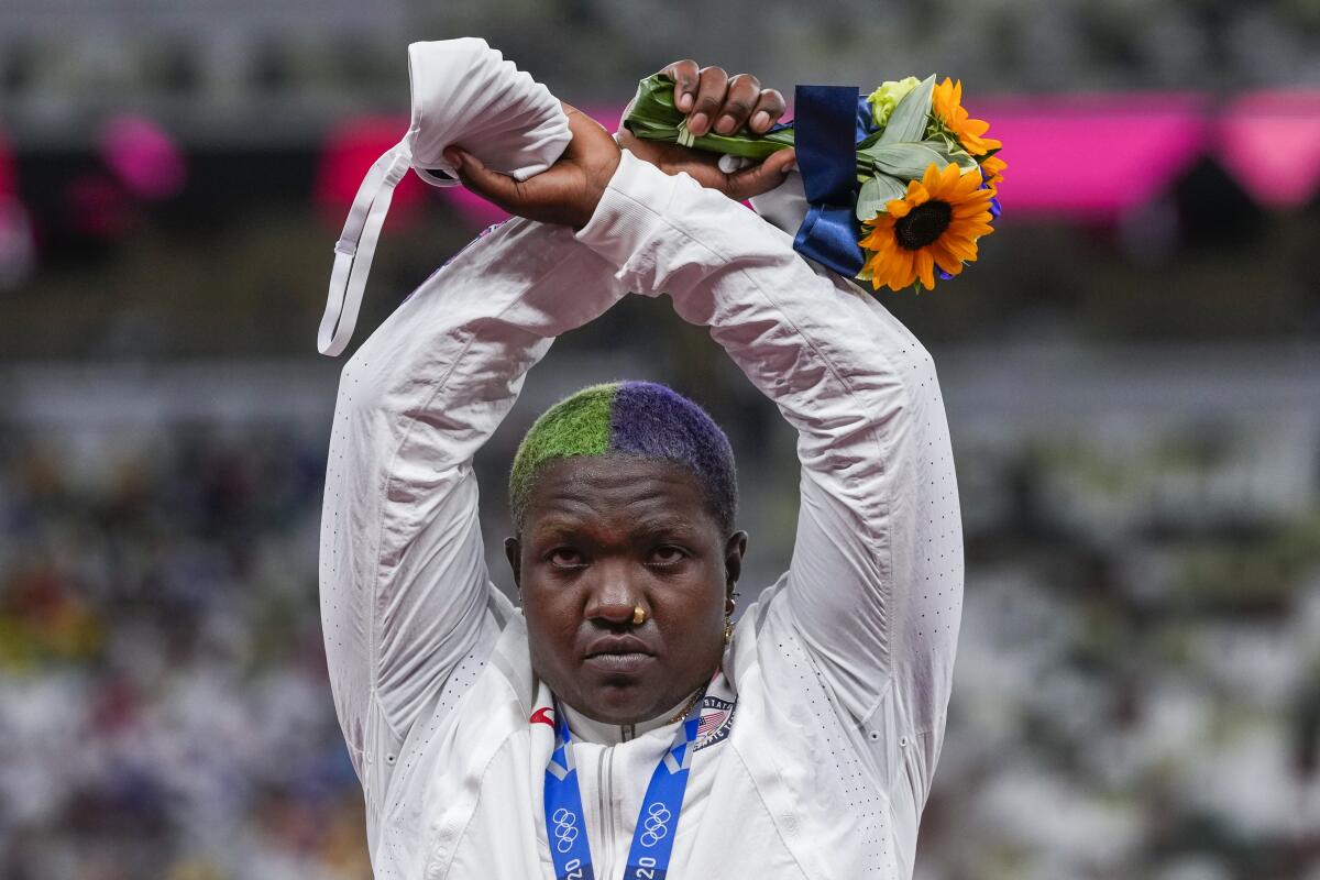 U.S. shot putter Raven Saunders poses with her silver medal on the podium at the Tokyo Olympics. 