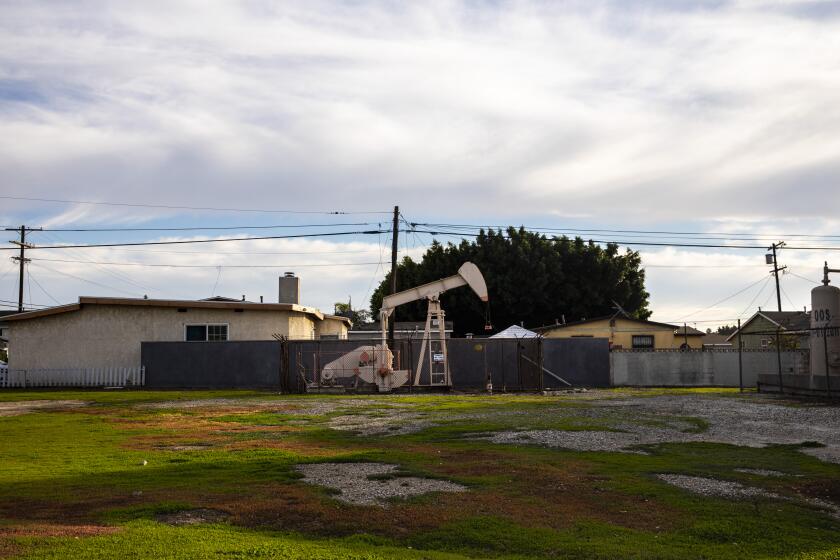 Los Angeles, CA - January 26: An Oil derrick pump is seen on a property, adjacent to homes, along W R Street, at Frigate Avenue, in the Wilmington neighborhood of Los Angeles, CA, Wednesday, Jan. 26, 2022. The Los Angeles City Council voted Wednesday to ban new oil and gas wells and to phase out existing wells over a five-year period.(Jay L. Clendenin / Los Angeles Times)