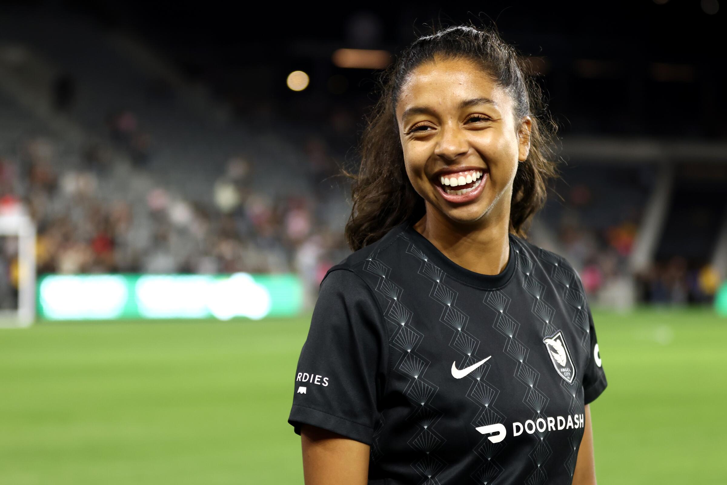 Madison Hammond laughs while standing on the pitch before an Angel City FC match against the Washington Spirt.