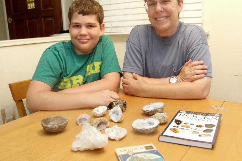 Kelly Duenckel and her son Robert Duenckel at home with some of the geodes and geology books in his collection.