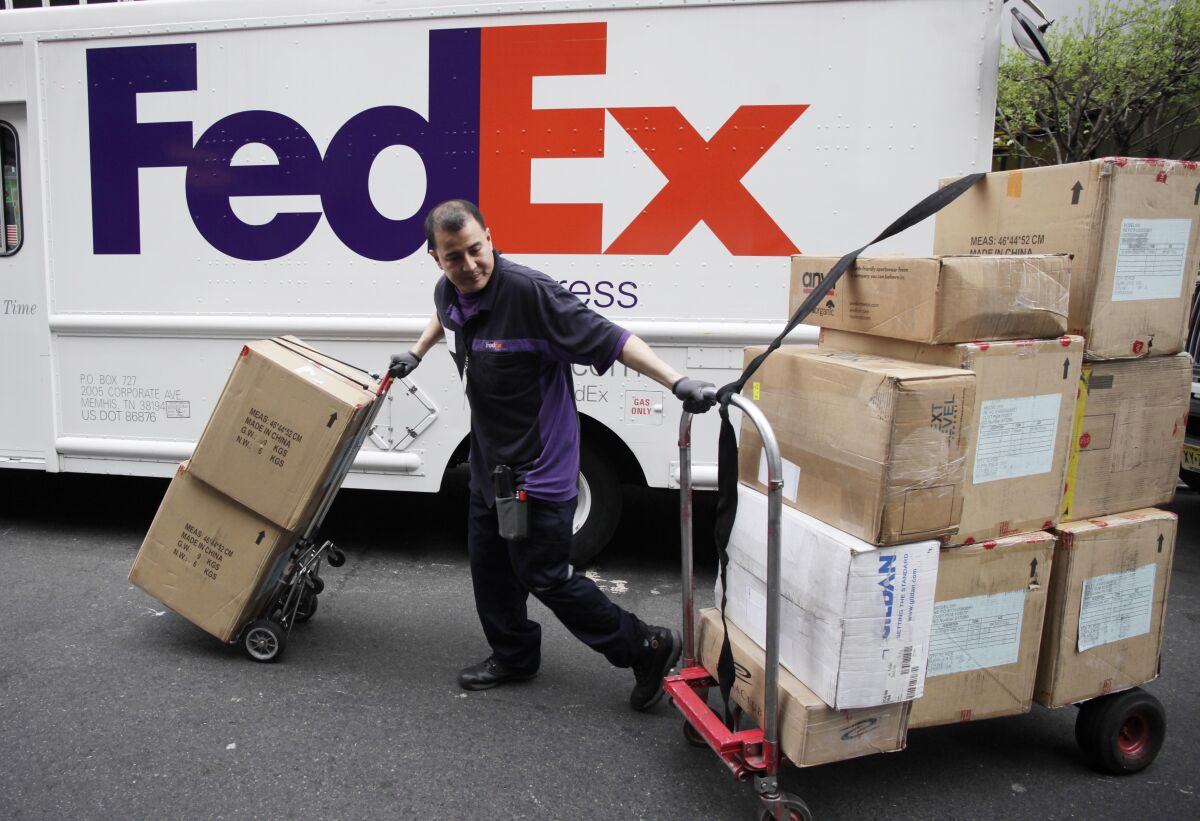 A FedEx driver carts packages