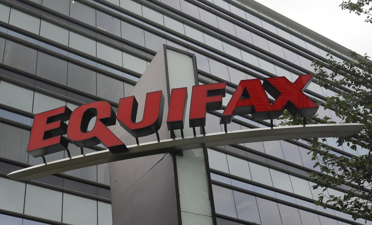 FILE- This July 21, 2012, file photo shows signage at the corporate headquarters of Equifax Inc. in Atlanta. A Florida woman has sued Equifax claiming she was denied a car loan because of a 130-point mistake she says was part of a larger group of credit score errors the ratings agency made last spring due to a coding problem. The class action lawsuit was filed in federal court in Atlanta, Thursday, Aug. 4, 2022. (AP Photo/Mike Stewart, File)