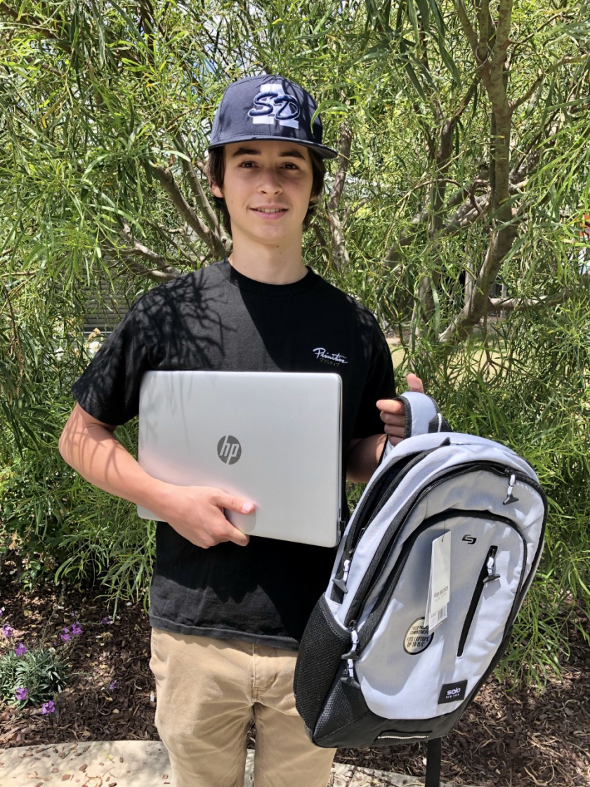 SDA student Joe Burke with his new laptop and backpack.