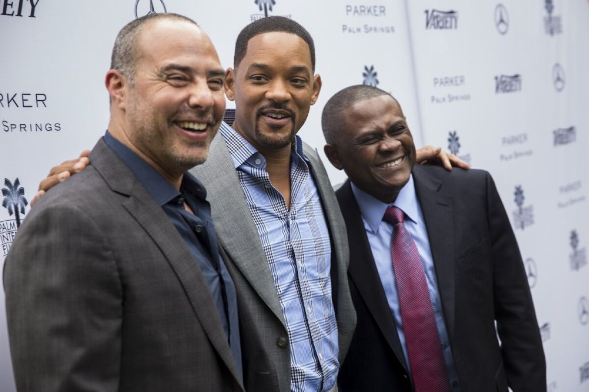 Dr. Bennet Omalu, right, the neuropathologist who found chronic traumatic encephalopathy in an American football player for the first time, with Peter Landesman, left, director of the movie 'Concussion,' and Will Smith.