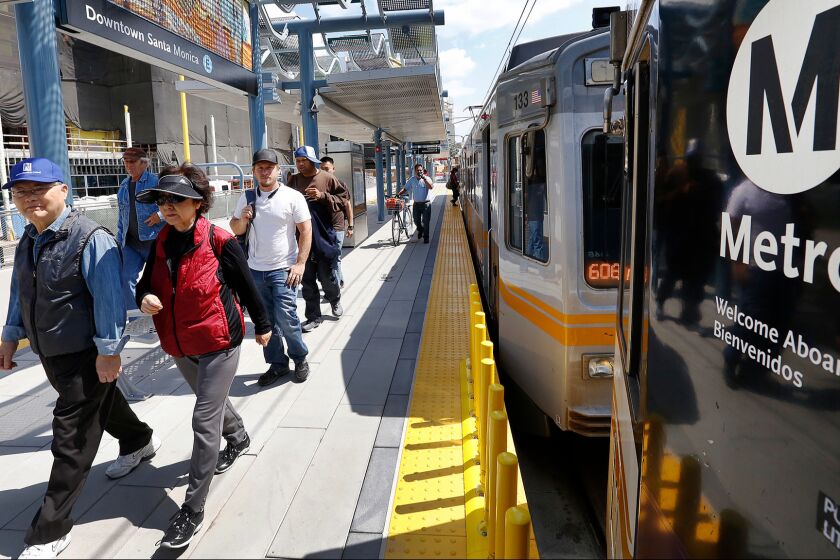 Commuters disembark from the Expo Line at the downtown Santa Monica station, which opened to service in May.