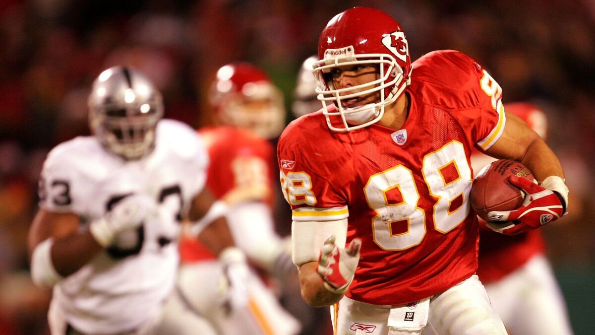 Tony Gonzalez (88) of the Kansas City Chiefs carries the ball up the field after making a catch against Oakland Raiders during the first half of the game at Arrowhead Field on December 25, 2004 in Kansas City, Missouri.