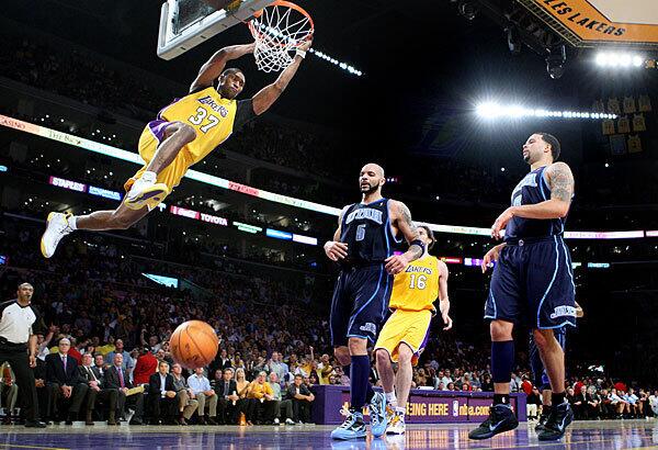 Lakers forward Ron Artest dunks over Utah forward Carlos Boozer, left, and guard Deron Williams in Game 2 of the Western Conference semifinals on Tuesday.
