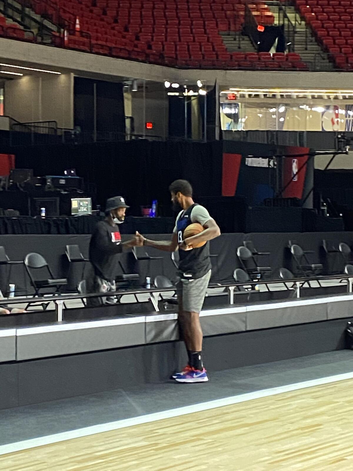 Clippers guard Patrick Beverley greets forward Paul George during the team's shoot-around Thursday morning in Orlando, Fla.